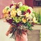 woman received a beautiful bouquet of red and beige roses, chrysanthemums and other flowers outdoors, toned image. Love and