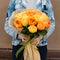 Woman received a beautiful bouquet of yellow and orange roses, o