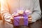 Woman received beautiful purple gift box with present in rays of