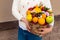 Woman received a new original unusual fruit bouquet, outdoors. C