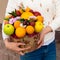 Woman received a new original unusual fruit bouquet, outdoors. C