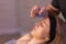 Woman receives facial cupping massage facial rejuvenation at acupuncture wellness spa.