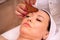 Woman receiving a facial madero massage with wooden massager