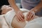 Woman receiving professional belly massage in wellness center, closeup