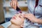 Woman receiving ultrasonic facial exfoliation at cosmetology salon.