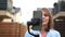 A woman is recording video using a smartphone with a stabiliser. Social media and video blogging, outdoor portrait woman