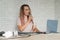 A woman records a vocal lesson using a laptop and accompanying on a keyboard while at home. The teacher sings a song