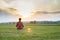 Woman is recovering in a lotus position against the backdrop of a sunny sunset