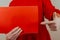 Woman on a red background in medical gloves holds a red poster. Close-up