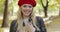 Woman in red beret walking in park