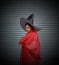 Woman with red cape cover the body and witch hat on stripe metal background