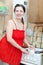 Woman in red cleans gas stove with melamine sponge