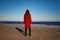 Woman in red coat on sandy beach