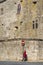 A woman in a red coat waits in Barcelos Portugal