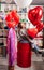 woman on red decorative barrel. with a large red balloons in the shape of heart.