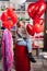 woman on red decorative barrel. with a large red balloons in the shape of heart.
