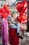 woman on red decorative barrel. with a large red balloons in the shape of heart.