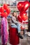 woman on red decorative barrel. with a large red balloons in the shape of heart.