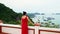 The woman in a red dress costs a back to the camera and looks at a bay of Vietnam. Beautiful view of a bay. Cat ba