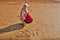 Woman in red dress with drawing on the sand digits 2017