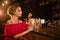 Woman in red dress drinks cocktail at bar counter