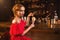 Woman in red dress drinks cocktail at bar counter