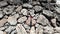 Woman in red dress with hands apart standing on rocks aerial top view shot. Drone shot of lady in red dress standing on rocky beac