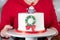 A woman in a red dress is holding a Christmas cake. Inscription Good Christmas. Happy holiday concept