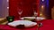 Woman in red dress lays out forks and spoons on festive table next to plates and glasses for champagne. Home cozy room