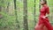 Woman In Red Dress Running Away In Forest