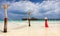 Woman in red dress takes photos in a Maldivian beach setting