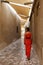 A woman in a red dress walking on a narrow street in Bastakia area of old town Dubai
