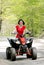 Woman in red on four wheeler