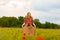 Woman with red hair shoots video in poppy field.