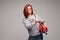 A woman with red hair in the Studio holding a fire extinguisher. An emotional bright woman extinguishes everything with