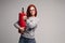 A woman with red hair in the Studio holding a fire extinguisher. An emotional bright woman extinguishes everything with