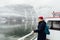 Woman in red hat standing on a ferry deck on the way to Hallstatt, Austria