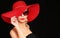 Woman in red hat and sunglasses over black