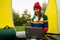 Woman in a red hat is working on a laptop while sitting in a tent
