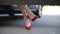 Woman in red high heels sitting in parked car