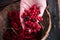 A woman in a red jacket collects red Viburnum berries in a basket