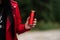 Woman in red leather jacket drinking cool soda cola drink from red can in hand. Woman drinking , showing blank can. girl