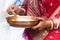 Woman in red mekhla holding religious offering