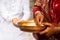 Woman in red mekhla holding religious offering