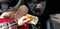 Woman in red mini dress in sport car holds in her hand Israeli money stack of new shekels