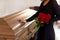 Woman with red roses and coffin at funeral