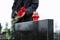 Woman with red roses, focus on candle. Funeral ceremony