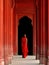 A woman in a red sari in an ancient Indian temple.