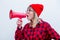 Woman in red shirt and hat with loud shout with megaphone