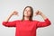 Woman in red sweater proud and confident, pointing fingers, example to follow